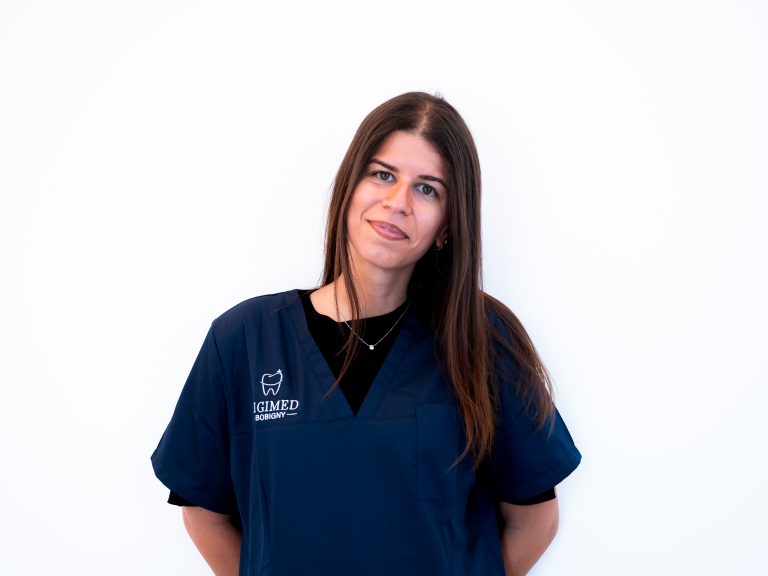 Portrait de la chirurgien-dentiste Alma Guez en blouse médicale souriant dans le cabinet