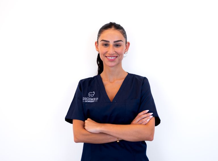 Portrait de la chirurgien-dentiste Anne-Sarah Benhamou en blouse médicale avec les bras croisés