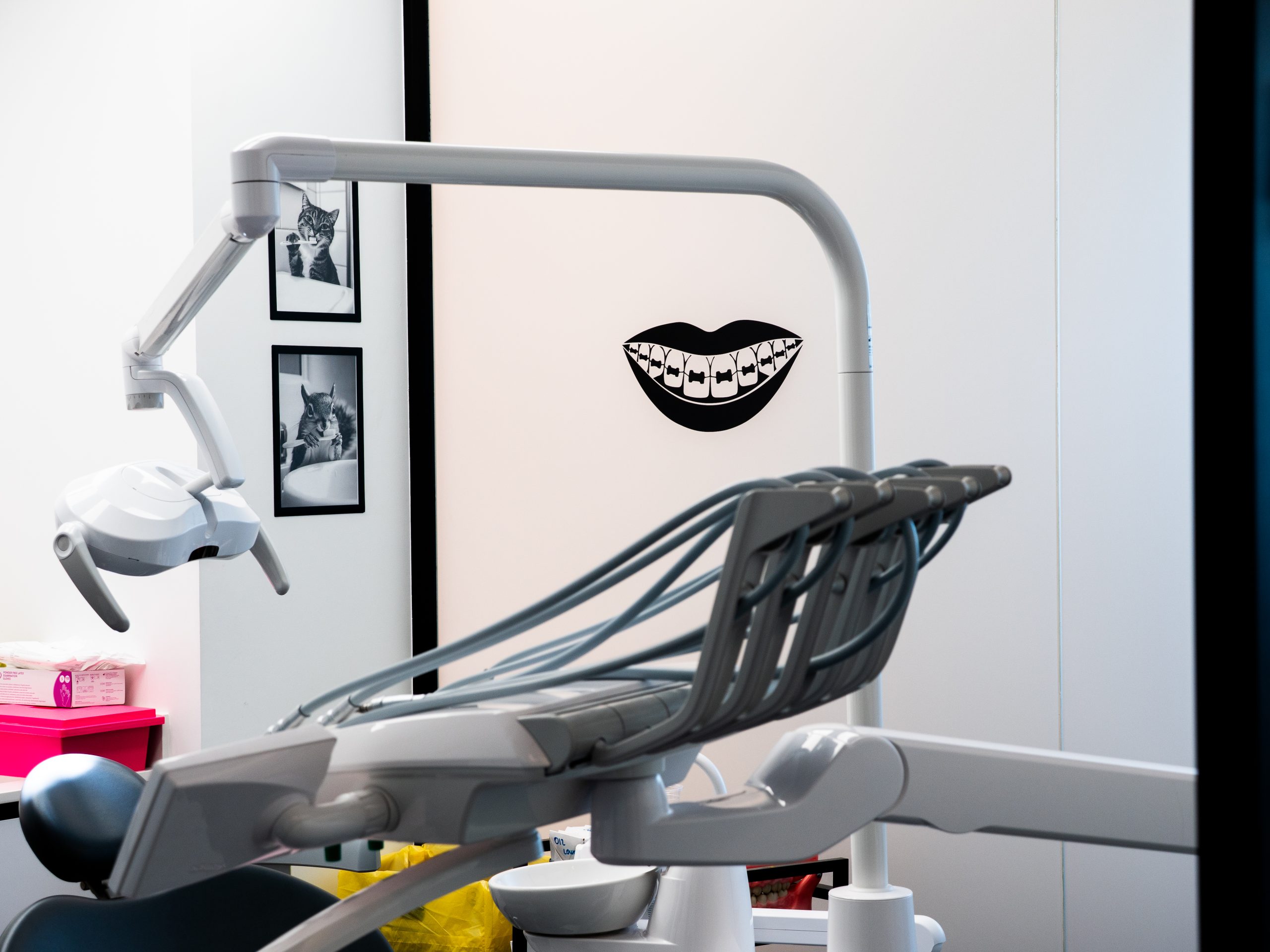 Vue d'un fauteuil dentaire avec un bras articulé et une décoration murale thématique en arrière-plan.