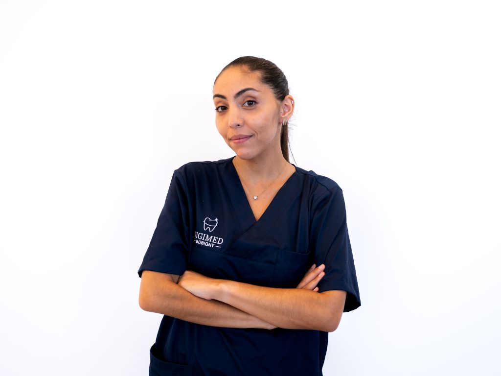 meriem-abdel-reheem-portrait Portrait de la chirurgien-dentiste Meriem Abdel Reheem en blouse médicale avec les bras croisés