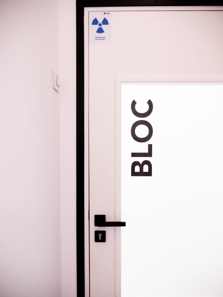 Porte d'accès au bloc avec signalétique réglementaire et symbole de sécurité.